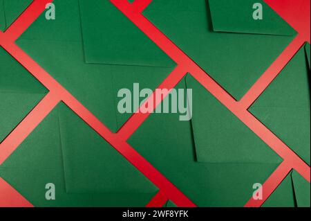 Top view of green envelopes on red background. Christmas, New Year composition. Post flat lay, copy space. Stock Photo