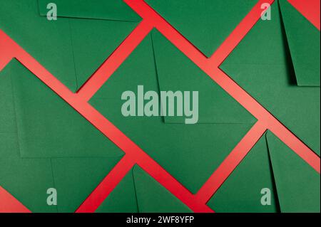 Top view of green envelopes on red background. Christmas, New Year composition. Post flat lay, copy space. Stock Photo