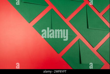 Top view of green envelopes on red background. Christmas, New Year composition. Post flat lay, copy space. Stock Photo