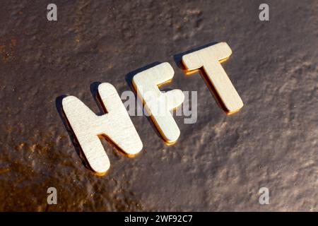 wooden nft letters on golden background Stock Photo