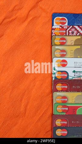 different credit cards with Mastercard brand logo. Close up of many Mastercard logos on credit cards. Plastic bank cards of Mastercard. International Stock Photo