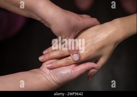 The masseuse massages the client's palms. Close-up of hands at a spa treatment. Stock Photo