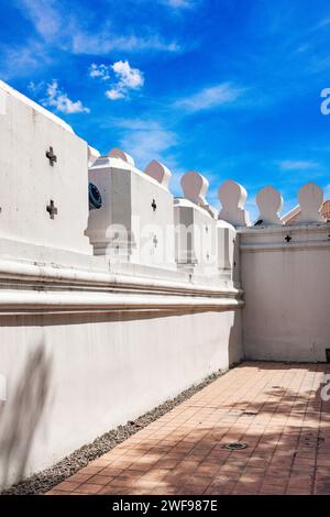 A captivating image of multiple white buildings neatly lined up against a vivid blue sky on a sunny day. Stock Photo