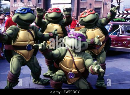 The Teenage Mutant Ninja Turtles (TMNT), in a  promotional shot for their rock show kicking off the COMINING OUT OF THEIR SHELLS hair metal tour, in front of Radio City Music Hall, New York, 1990.  Photo: Oscar Abolafia/Everett Collection  (teenagemutantturtles003) Stock Photo