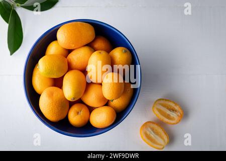 Fresh kumquat in a blue bowl on a white background Stock Photo