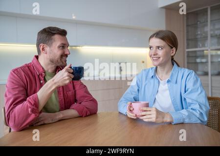 Sentimental loving couple spending pastime together weekends at home, drinking tea, coffee, speaking Stock Photo