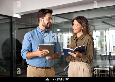 Happy busy latin business people working and talking in office. Stock Photo