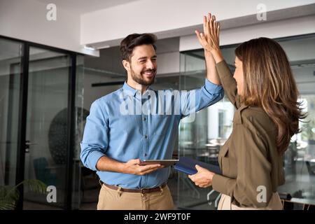Happy business team two executives giving high five at work in office. Stock Photo