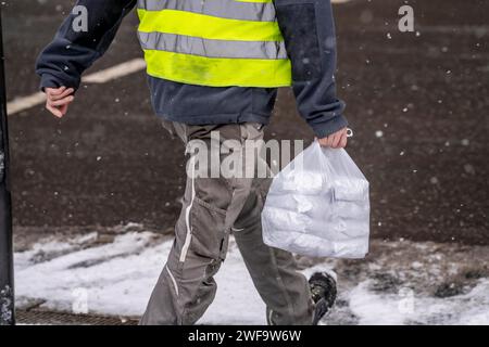 Winter in Frankfurt, worker of a large construction site has bought lunch for himself and colleagues, at a snack bar, snowy, Hesse, Germany Stock Photo