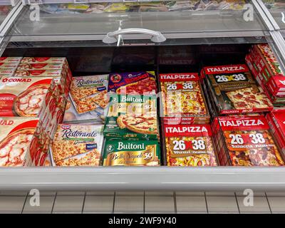 Italy - January 26, 2024: Pre-cooked frozen pizza in packs of various brands displayed in a refrigerated counter for sale in an Italian supermarket, t Stock Photo