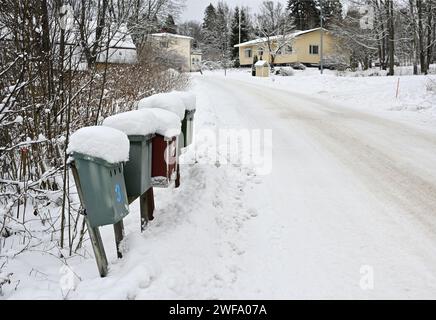 snow covered mailboxes and a road in a small Finnish town in winter Stock Photo
