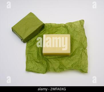 bar of soap on green paper wrapper on white background Stock Photo