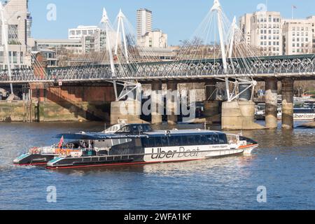 An Uber Boat, river bus service by Thames Clippers, approaching Hungerford Bridge, London, England, UK Stock Photo