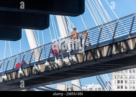 Pedestrians people walking across one the Golden Jubilee bridges next to Hungerford Bridge, River Thames, Central London, England, UK Stock Photo