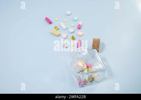 White color pills scattered on the table, close-up. Many pills in capsule form on the table. The pills spilled out of the bottle. copy space Stock Photo