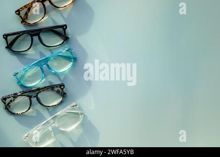 An Assortment of Blue Light Blocking Reading Glasses on Light Blue Solid Background with Copy Space Stock Photo