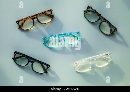 An Assortment of Blue Light Blocking Reading Glasses on Light Blue Solid Background Stock Photo