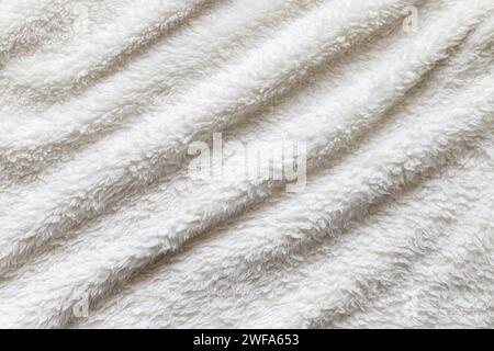 White plush fabric plaid. Wavy warm cozy blanket background. Stock Photo