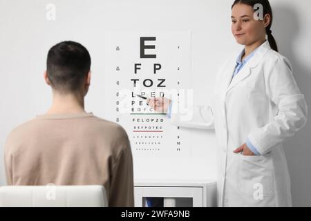 Ophthalmologist testing young man's vision in clinic Stock Photo