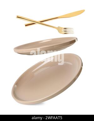 Clean plates, fork and knife falling on white background Stock Photo