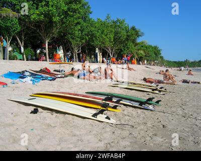 Sunbathers and surfboards on Kuta Beach in Bali, Indonesia. Stock Photo