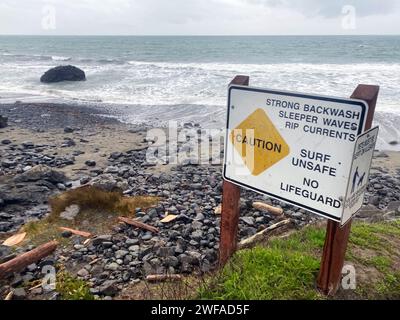 Sign at a dangerous beach: Caution: Strong Backwash, Sleeper Waves, Rip Currents, Surf Unsafe, No Lifeguard Stock Photo