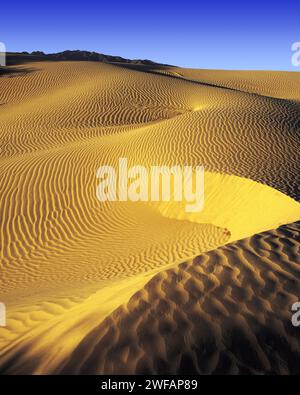 Early morning light on sand-dunes in Death Valley, distant tops of the Panamint Mountains just visible, California, USA Stock Photo