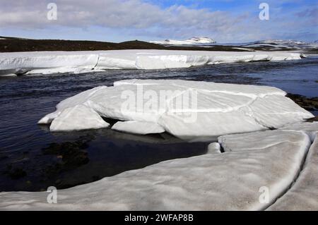 Spring melt in the Miohusaa river above the town of Egilstadir, with a distant view of the Fjardarheidi mountains, east Iceland Stock Photo