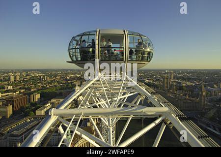 Close-up on a section of the main wheel and one of the passenger cabins on the London Eye at the top of its travel with an evening view of London Stock Photo