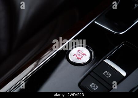 Start engine stop button Interior of modern luxury car. Details of automatic transmission gear shift, multimedia control system, car control panel, Air Vent Red emergency button and dashboard inside. Prestige sport automobile. Selective focus Stock Photo