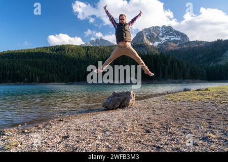 happy young bearded man jumps for joy being in nature Stock Photo
