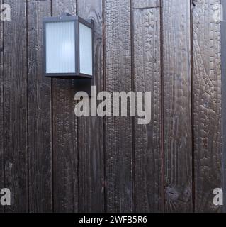 Modern external lamp on burned wood wall Stock Photo