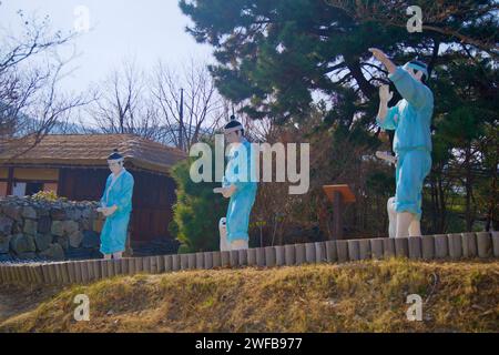 Samcheok City, South Korea - December 28, 2023: Three unique fishermen sculptures, each holding their phallic representation, adorned in greenish-blue Stock Photo