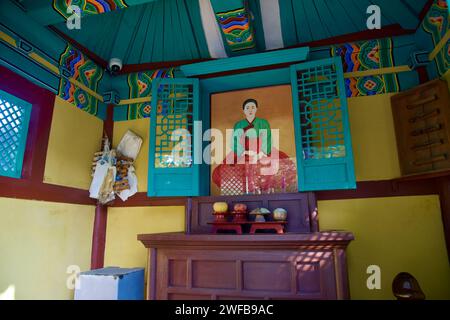 Samcheok City, South Korea - December 28, 2023: Inside the shrine, a painting of the lost young maiden adorns the wall, accompanied by offerings of fr Stock Photo