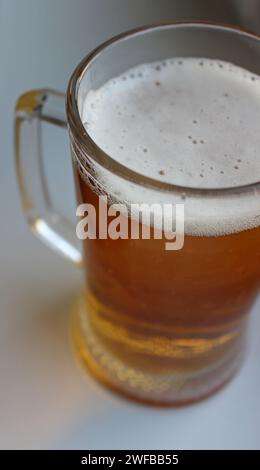 Beer glass with massive handle filled with chilled beer closeup top view Stock Photo