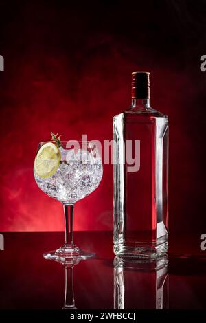 Gin tonic on red background with smoke with copyspace. Vertical format. Stock Photo