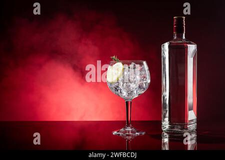 Gin tonic on red background with smoke with copyspace. Stock Photo