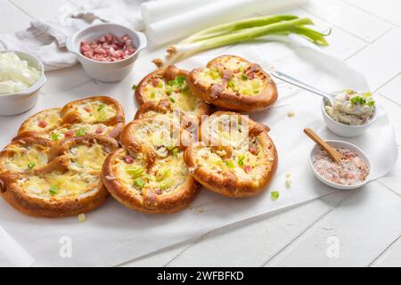 Homemade delicious traditional Bavarian Brezeln or pretzels baked with cream cheese, bacon and onions Stock Photo