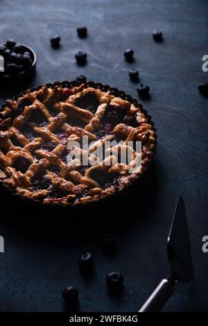 Red fruit and blueberry pie presented on a dark blue background. Stock Photo