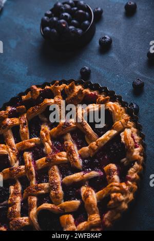 Red fruit and blueberry pie presented on a dark blue background. Stock Photo