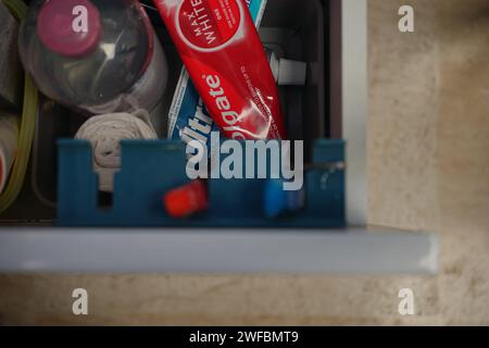 Opened bathroom drawer containing toothbrushes toothpaste dental care products and self care products Stock Photo