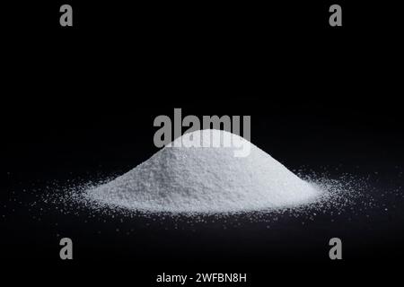 White quartz sand on a black background in the form of a slide. quartz sand is used in finishing construction materials, water treatment and agricultu Stock Photo