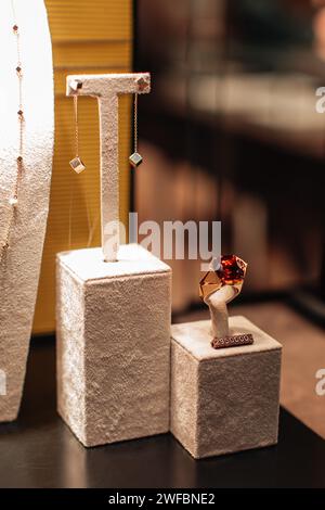 Earrings and gold ring with a huge ruby on the counter in a jewelry boutique. Expensive accessories for gifts for women Stock Photo