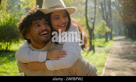 Happy smiling loving multiethnic married couple african american man hispanic woman walking in park outdoors romantic date in nature guy move holding Stock Photo