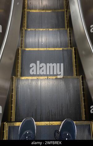 my feet going down an escalator Stock Photo