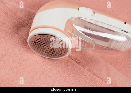 Machine for removing pellets. A special device to remove lint from clothes. Restoration of old damaged clothes Stock Photo