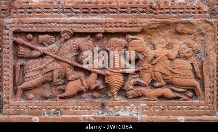 Closeup view of carved terracotta tiger hunting scene with hunters riding horses on ancient Govinda temple in Puthia, Rajshahi, Bangladesh Stock Photo