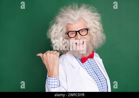 Photo of excited positive man indicate thumb empty space feedback tips offer isolated on dark green color background Stock Photo