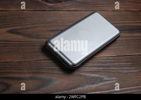 Power bank for charging mobile devices on wooden background. External battery for mobile devices Stock Photo