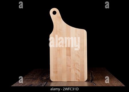 New wooden cutting board on a dark background. Copy space. Stock Photo